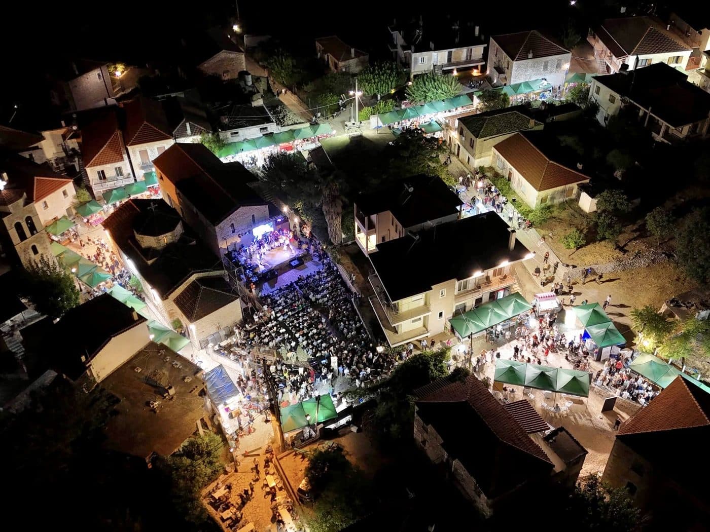 Aerial view of the village with the lit fair stands and the stage