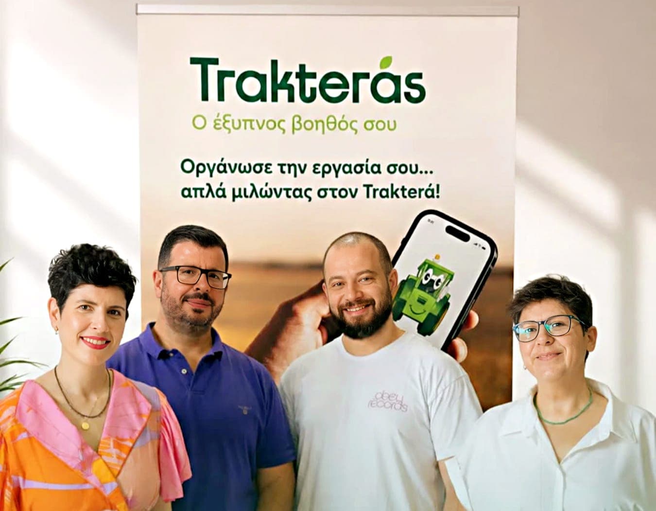 Η τετραμελής ομάδα του Trakterás μπροστά από banner με το λογότυπο